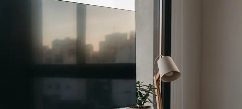 Monitor sobre un escritorio de roble frente a una ventana con vista a los techos de Buenos Aires