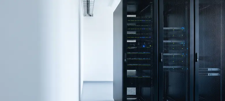 Sala de servidores ordenada con racks negros de puerta perforada y luces de estado encendidas